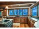 Rustic kitchen boasts granite counters, custom wood cabinets, stainless sink, and scenic views from expansive windows at 59 Gold Run Rd, Breckenridge, CO 80424