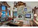 Cozy living room with a grand stone fireplace, wood beams, and leather furniture at 59 Gold Run Rd, Breckenridge, CO 80424