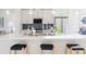 Modern kitchen boasts a large island with seating, stainless steel appliances, and white cabinetry at 10860 Lyric St, Lone Tree, CO 80134