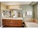 Well-lit bathroom with double sinks, tub, and wooden cabinets offering plenty of storage space at 10505 Wheeling St, Commerce City, CO 80022