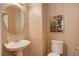 Powder room featuring a pedestal sink, round mirror, and modern commode at 10505 Wheeling St, Commerce City, CO 80022