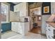Charming kitchenette featuring white cabinetry, tile backsplash, sink, and view to hallway at 3907 S Lincoln St, Englewood, CO 80113