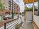 This front porch has a wooden bench with a view of the street and the nearby apartment building at 4025 Jason St # 101, Denver, CO 80211