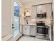 Stylish kitchen with stainless steel appliances, gray cabinets, and access to outdoor patio at 4025 Jason St # 101, Denver, CO 80211