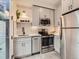 Modern kitchen featuring stainless steel appliances, gray cabinets, stylish backsplash, and ample counter space at 4025 Jason St # 101, Denver, CO 80211