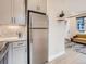 Modern kitchen with stainless steel refrigerator and view into the living area at 4025 Jason St # 101, Denver, CO 80211