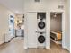Space-saving stacked laundry unit in closet, with views into the modern kitchen and bedroom at 4025 Jason St # 101, Denver, CO 80211