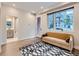 Sunlit living room features hardwood floors, stylish rug, comfortable sofa, and adjacent bathroom at 4025 Jason St # 101, Denver, CO 80211