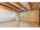 Finished basement showcasing wood beam ceiling and tile floors, ample natural light at 5073 N Lariat Dr, Castle Rock, CO 80108