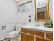 Half bathroom featuring white walls, a vanity with white countertop and wood cabinets, and a toilet at 5073 N Lariat Dr, Castle Rock, CO 80108