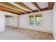 Bedroom featuring exposed wood beams, large mirrored closet, and natural light at 5073 N Lariat Dr, Castle Rock, CO 80108