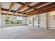 Open living area with exposed wood beams, large windows providing ample light, and built-in shelving at 5073 N Lariat Dr, Castle Rock, CO 80108