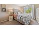 Bedroom features a plush bed, accent lamps, and a bright window with a view of green trees at 4194 Beautiful Cir, Castle Rock, CO 80109