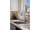 Close-up of a stainless-steel kitchen sink, faucet, and tile backsplash by a window at 4194 Beautiful Cir, Castle Rock, CO 80109