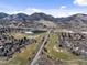 Picturesque view of homes near a lake and golf course, with mountains in the distance at 16052 Deer Ridge Dr # B, Morrison, CO 80465
