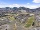 Overhead view of the golf course community with lush green fairways, ponds, and the backdrop of the Rocky Mountains at 16052 Deer Ridge Dr # B, Morrison, CO 80465