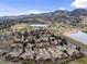 Aerial view of a neighborhood bordering a golf course, lakes, and distant mountains at 16052 Deer Ridge Dr # B, Morrison, CO 80465