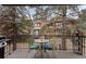 Deck with black metal railing, grill, table and chairs, and view of trees and other properties at 16052 Deer Ridge Dr # B, Morrison, CO 80465