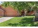 Well-manicured front yard featuring mature trees, green grass, and a brick facade at 16052 Deer Ridge Dr # B, Morrison, CO 80465