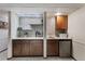 Basement wet bar with custom shelving, wine rack, sink, and stainless-steel refrigerator at 16052 Deer Ridge Dr # B, Morrison, CO 80465