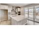 Modern kitchen with white cabinets, island, and sliding glass doors at 4304 Ridgewalk Pt, Castle Rock, CO 80108