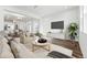 Open living room with large TV, light colored furniture, and hardwood floors at 4304 Ridgewalk Pt, Castle Rock, CO 80108