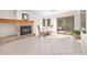 Cozy dining area with brick fireplace, sliding doors to backyard, and tile floors at 6868 Johnson St, Arvada, CO 80004