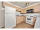 Kitchen features wooden cabinets, white appliances, and tile backsplash, creating a functional cooking space at 6868 Johnson St, Arvada, CO 80004