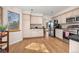 Bright kitchen featuring wood floors, stainless appliances, light cabinets, and an open view to the dining room at 6868 Johnson St, Arvada, CO 80004
