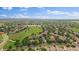 Sprawling aerial view of a neighborhood with a golf course and lake, surrounded by green spaces and housing at 5107 Pasadena Way, Broomfield, CO 80023
