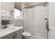 Bright bathroom with glass enclosed tiled shower and gray vanity with framed mirror at 8110 S Kellerman Cir, Aurora, CO 80016
