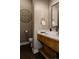 Modern bathroom featuring a vessel sink, floating wood vanity, designer fixtures, and stylish wall decor at 8110 S Kellerman Cir, Aurora, CO 80016