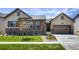 Beautiful single Gathering home with a stone and wood facade, a metal roof and a well manicured lawn at 8110 S Kellerman Cir, Aurora, CO 80016