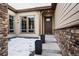 Inviting front entrance featuring a modern door, decorative stone accents, and tasteful landscaping at 8110 S Kellerman Cir, Aurora, CO 80016