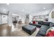 Spacious living room featuring a plush sectional, open floor plan, and access to additional living spaces at 8110 S Kellerman Cir, Aurora, CO 80016