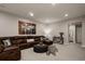 Spacious living room featuring a large sectional, accent rug, and adjacent bathroom at 8110 S Kellerman Cir, Aurora, CO 80016