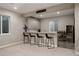 Wet bar featuring bar-top seating, upper and lower cabinets, and wine fridge at 8110 S Kellerman Cir, Aurora, CO 80016
