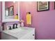 Colorful bathroom featuring a white vanity with sink, modern faucet, vanity mirror, and light purple walls at 48 Galapago St, Denver, CO 80223