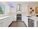 Modern kitchen with sleek white cabinets, quartz countertops, and stainless steel appliances, perfect for culinary enthusiasts at 48 Galapago St, Denver, CO 80223