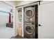 Convenient laundry closet featuring a stacked washer and dryer, with storage shelves, located off the bedroom at 48 Galapago St, Denver, CO 80223