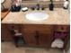 Close-up of a wooden bathroom vanity with a white undermount sink and granite countertop at 6711 S Ivy Way # B5, Centennial, CO 80112