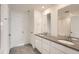 Modern bathroom with double vanity, gray countertops, white cabinetry, tile flooring and a glass-enclosed shower at 2058 S Haleyville Way, Aurora, CO 80018