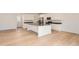 Modern kitchen with a large island, stainless steel appliances, white cabinetry, and hardwood floors at 2058 S Haleyville Way, Aurora, CO 80018