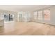 Spacious, light-filled open-concept living space with hardwood floors, many windows, and sleek white walls at 2058 S Haleyville Way, Aurora, CO 80018