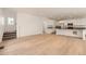 Open-concept living space with hardwood floors and a modern kitchen featuring white cabinets and a dark countertop island at 2058 S Haleyville Way, Aurora, CO 80018
