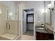 Modern bathroom featuring walk-in glass shower, single vanity, and entry to walk-in closet at 5455 Landmark Pl # 407, Greenwood Village, CO 80111