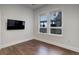 Well lit bedroom with hardwood floors, mounted TV, and a large double window at 5455 Landmark Pl # 407, Greenwood Village, CO 80111