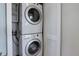 A stacked white washer and dryer unit are placed within a bright laundry space at 5455 Landmark Pl # 407, Greenwood Village, CO 80111