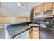 Basement bar area with granite countertop, natural wood cabinets, and view to the living area at 822 Shadowstone Dr, Highlands Ranch, CO 80129