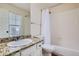 Bright bathroom with white cabinets, granite countertops, and a shower-tub combination, creating a comfortable functional space at 822 Shadowstone Dr, Highlands Ranch, CO 80129